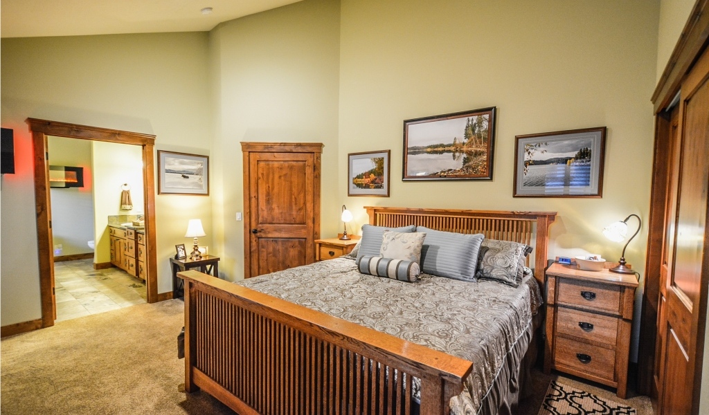 Большая деревянная двуспальная кровать в комнате