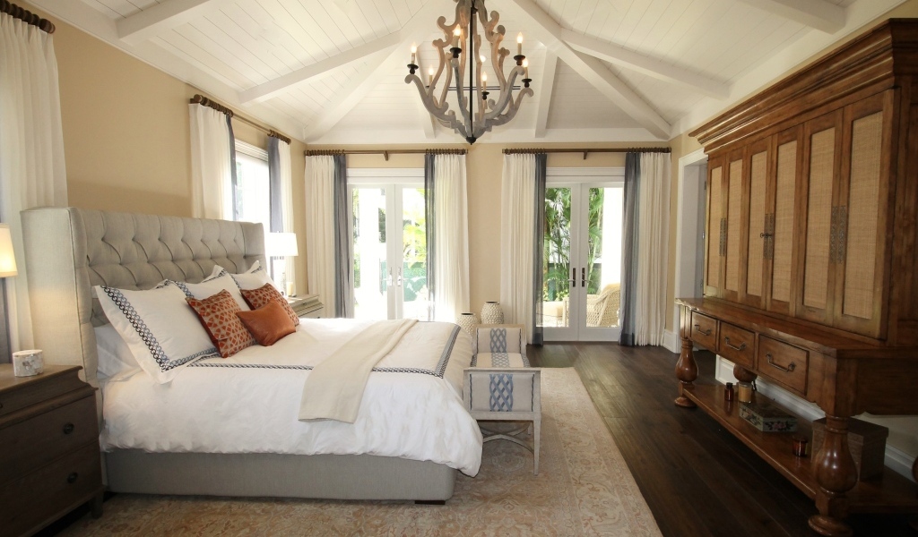 Большой деревянный шкаф в спальне с большой кроватью