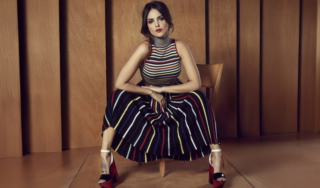 Мексиканская актриса Эйса Гонсалес в юбке сидит на стуле