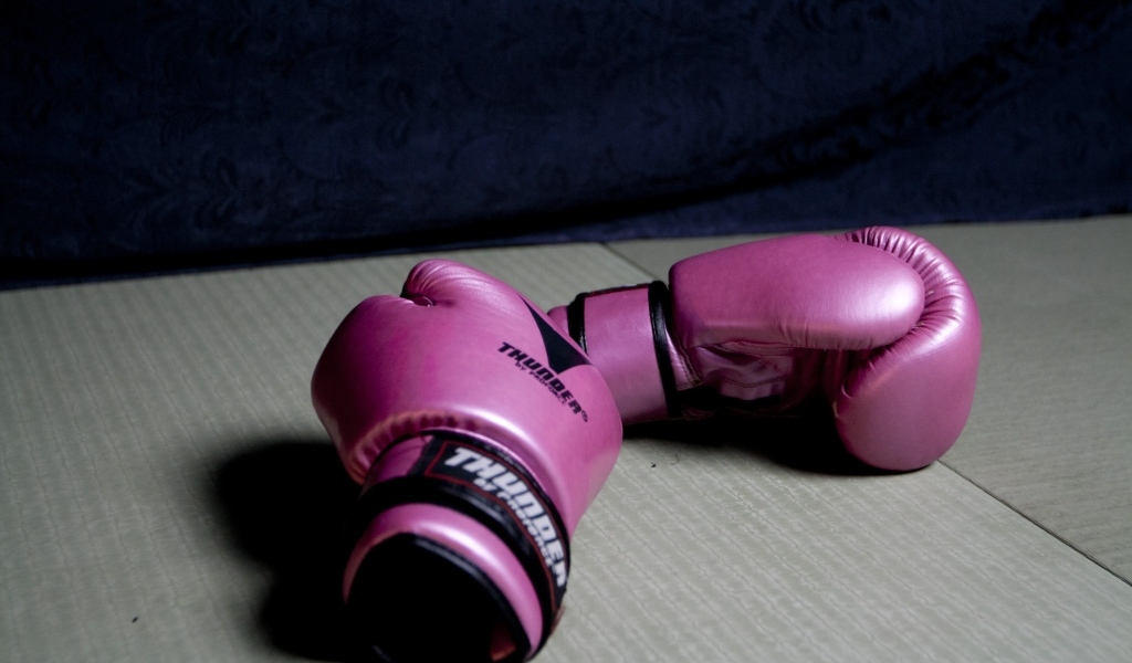 Розовые боксерские перчатки на столе 