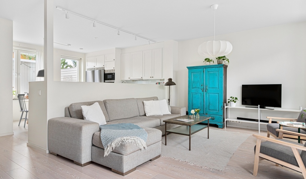 Просторная гостиная комната  с серым диваном