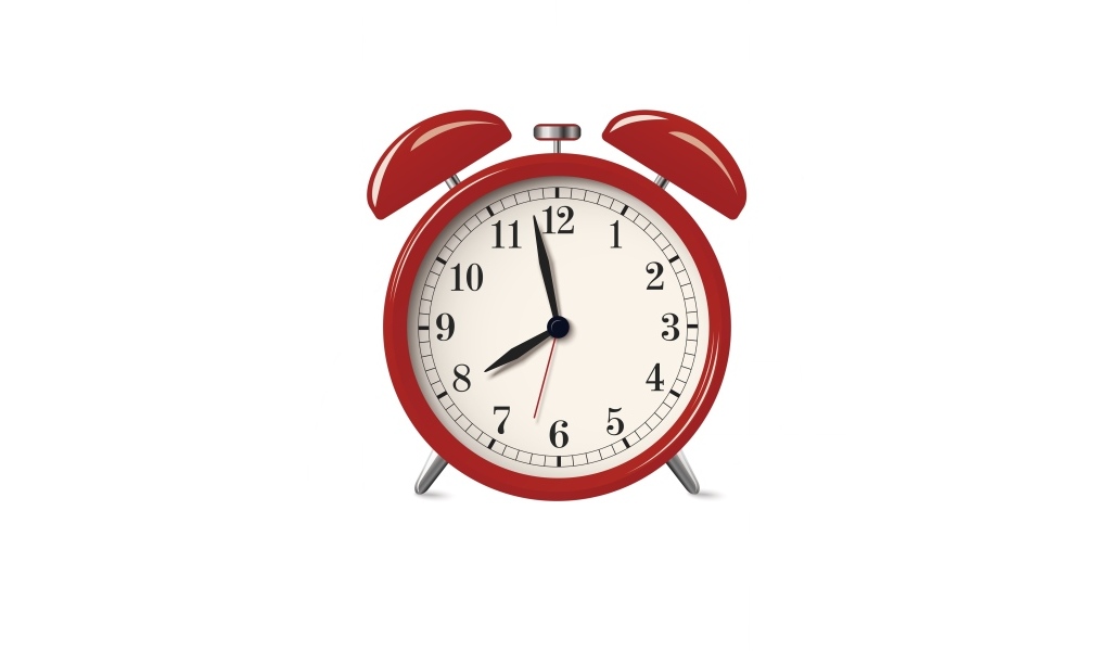 Красный будильник на белом фоне