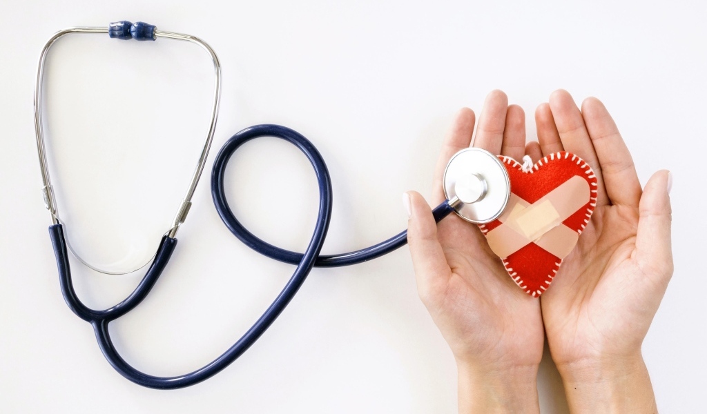 Стетоскоп слушает раненое сердце в ладонях