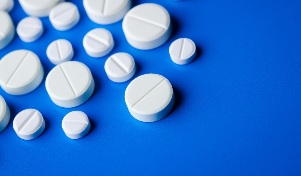 Белые таблетки на синем фоне