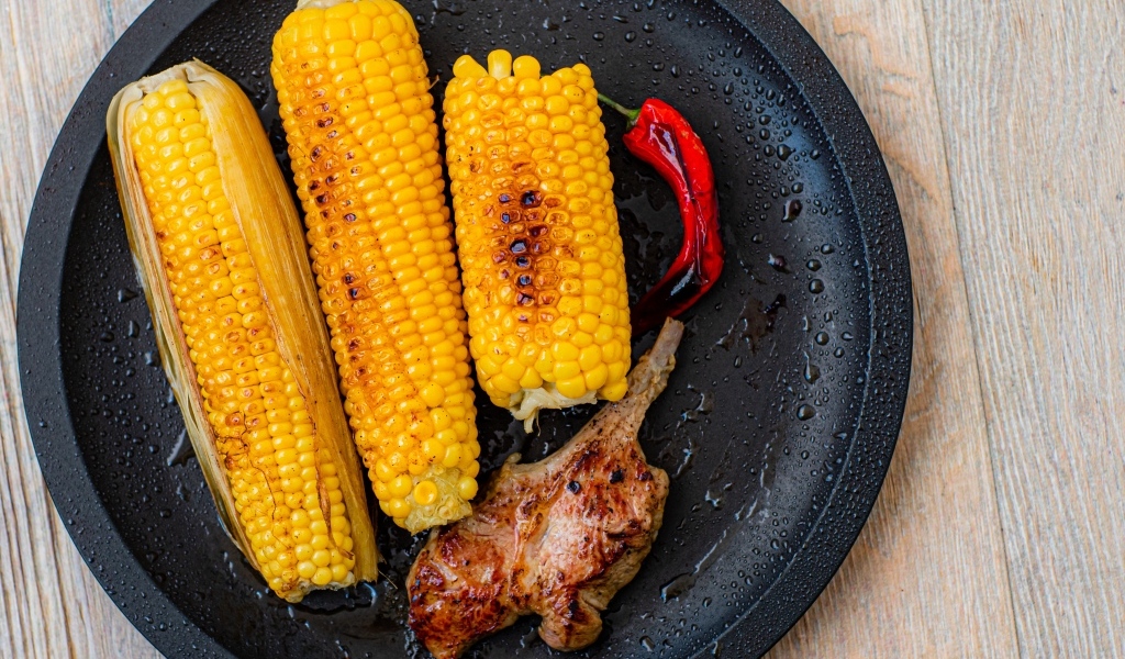 Запеченная кукуруза с ребрышками на тарелке