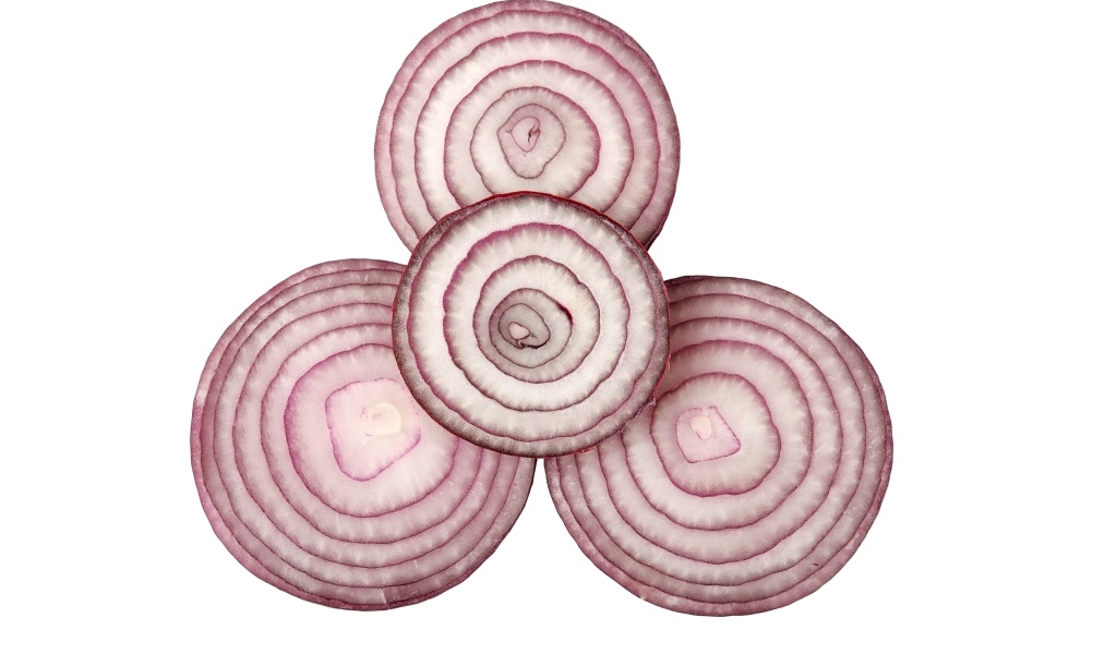 Кольца красного лука на белом фоне крупным планом