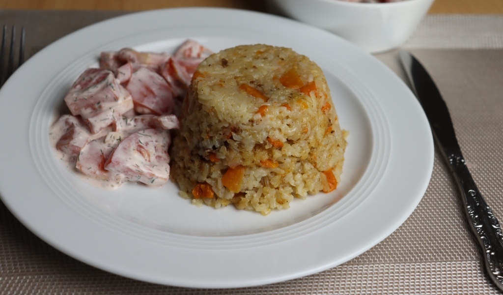 Рис с салатом на большой белой тарелке