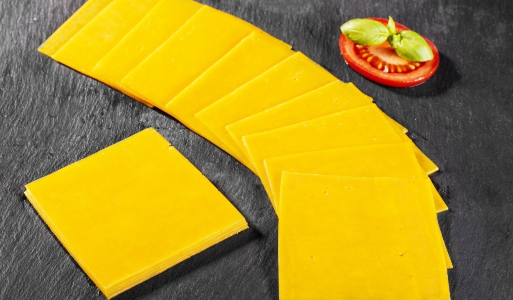 Ломтики сыра с помидором на столе