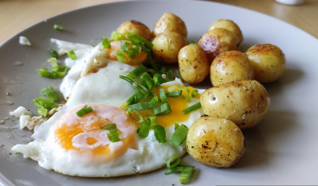 Молодая жареная картошка с яичницей и зеленым луком