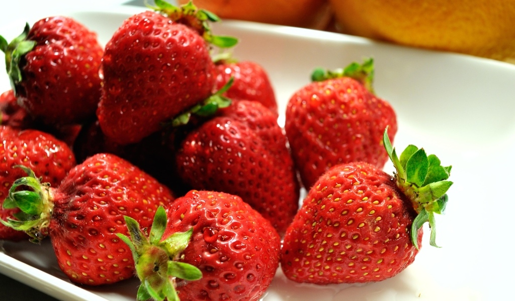 Ароматная красная клубника в белой тарелке