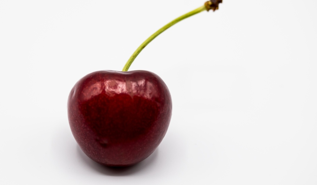 Крупная красная черешня на белом фоне