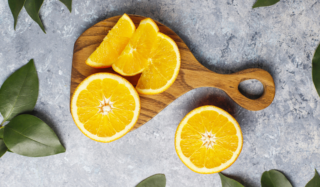 Апельсин на разделочной доске кусочками