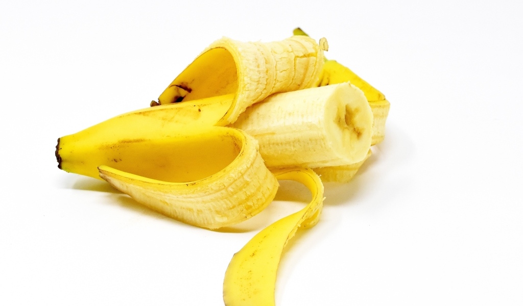 Очищенный банан на белом фоне