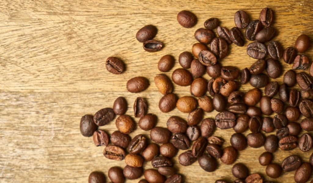 Жареные кофейные зерна на деревянном столе