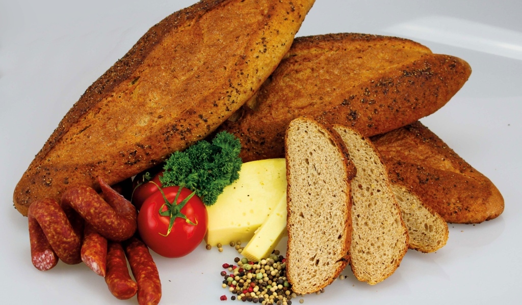 Свежая выпечка на столе с колбасой, сыром и помидорами