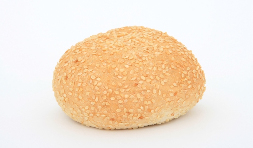 Булочка с кунжутом на белом фоне