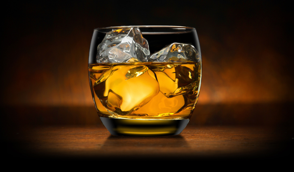Стакан виски со льдом на столе