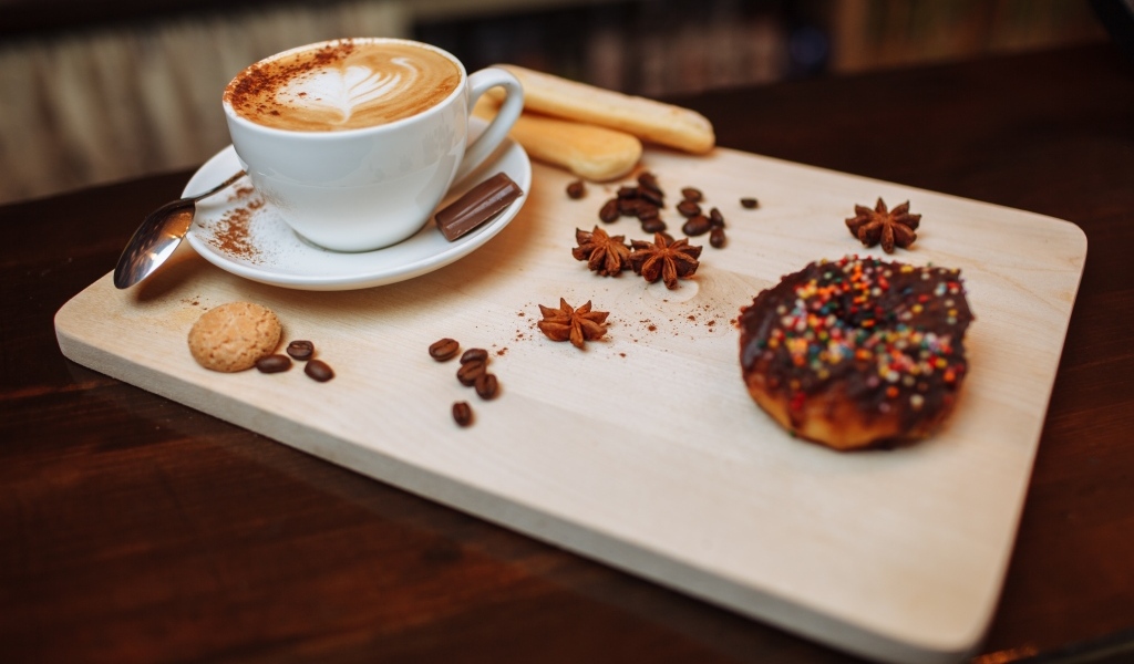 Чашка кофе на доске со специями и печеньем