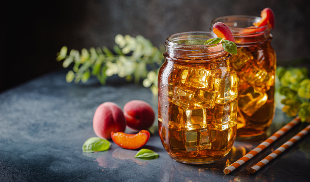 Холодный чай со льдом на столе с абрикосами