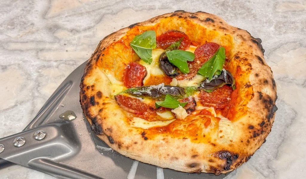 Маленькая пицца на лопате на столе