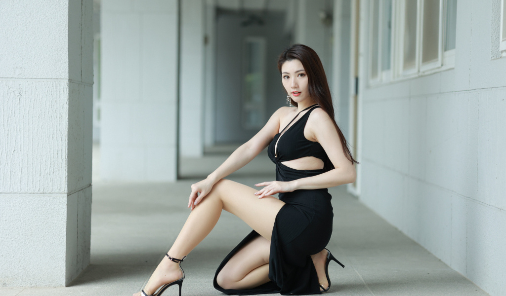 Девушка азиатка в черном наряде позирует для фото
