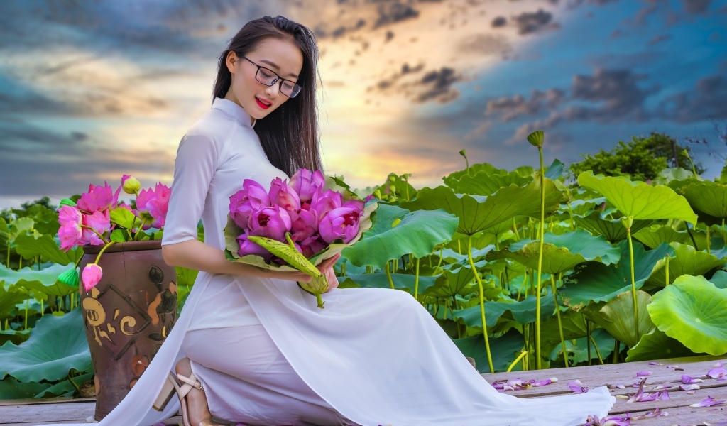 Девушка азиатка в белом платье с цветами лотоса