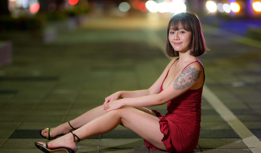 Азиатка с татуировкой на руке в красном платье
