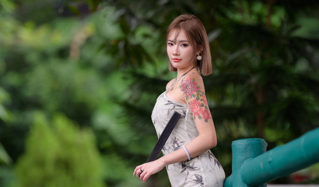 Красивая девушка азиатка с татуировкой на руке
