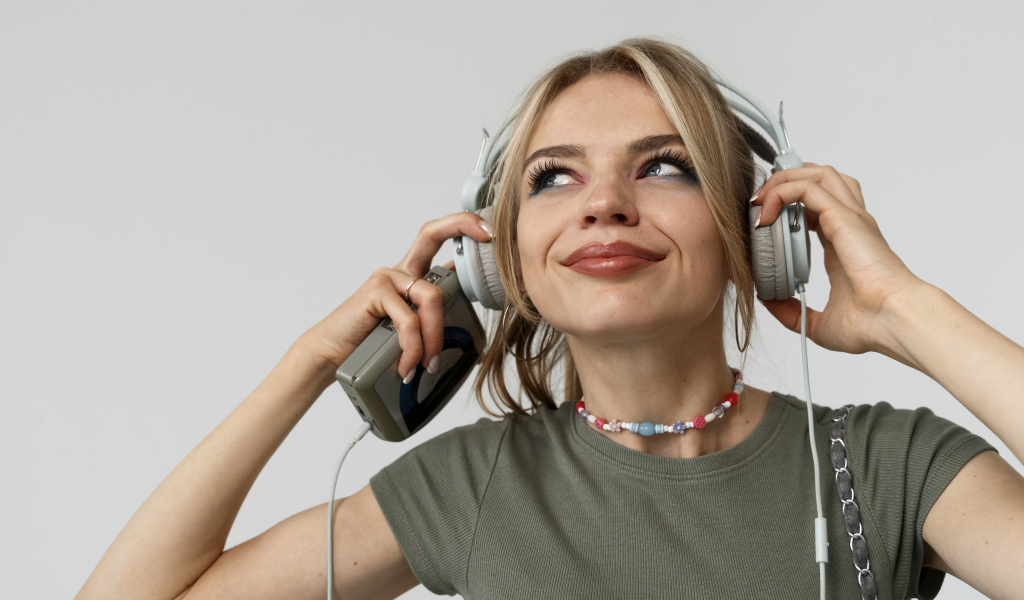 Красивая девушка в наушниках с плеером