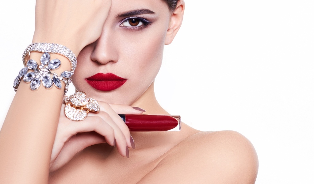 Красивая девушка с красной губной помадой в руке