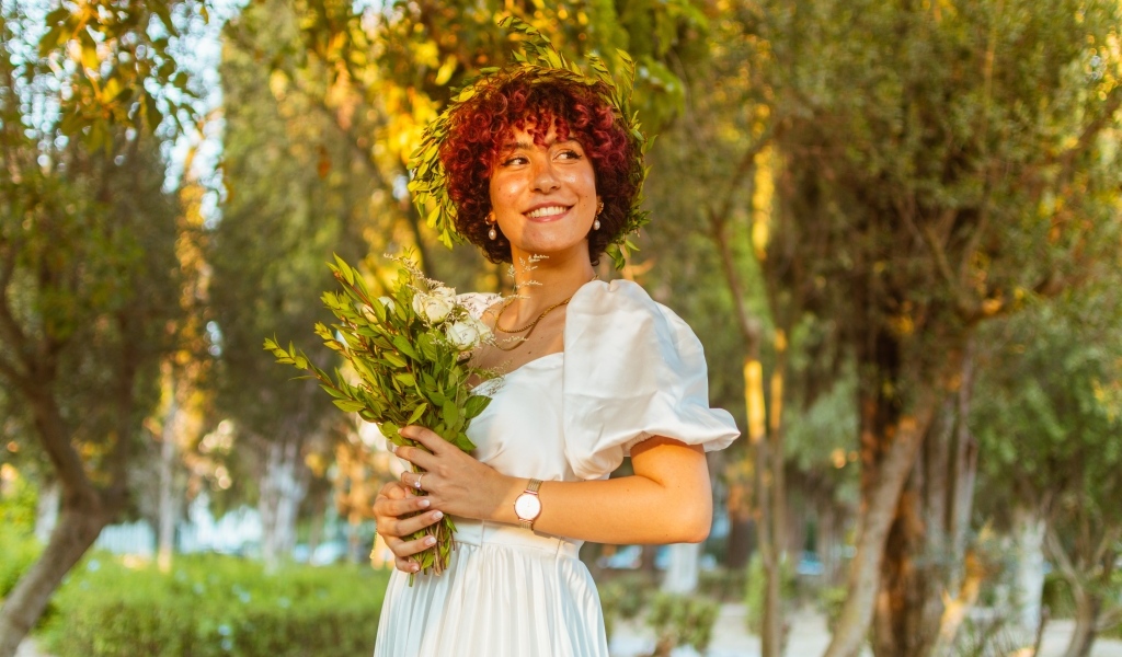 Красивая улыбающаяся рыжеволосая девушка с букетом