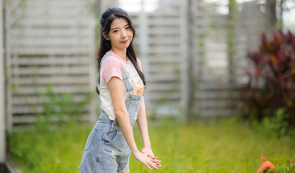 Милая девушка азиатка в джинсовом комбинезоне