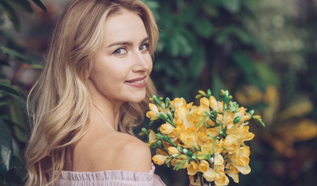 Милая девушка с букетом желтых цветов в руках
