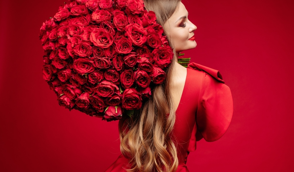 Девушка в красном платье с большим букетом роз