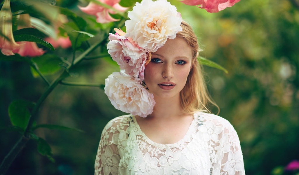 Девушка в белом платье с цветами пиона на голове