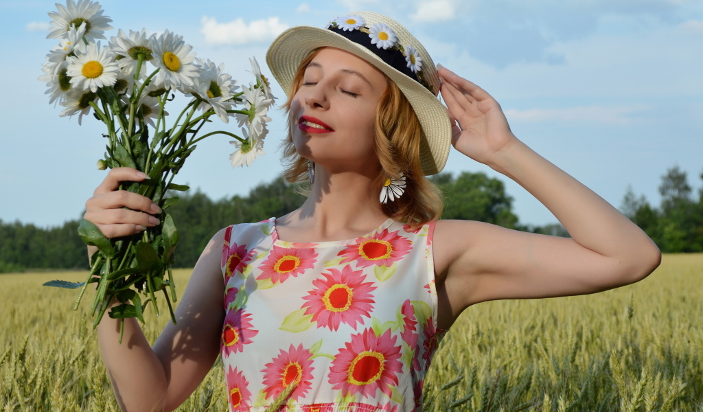 Девушка с букетом ромашек на поле