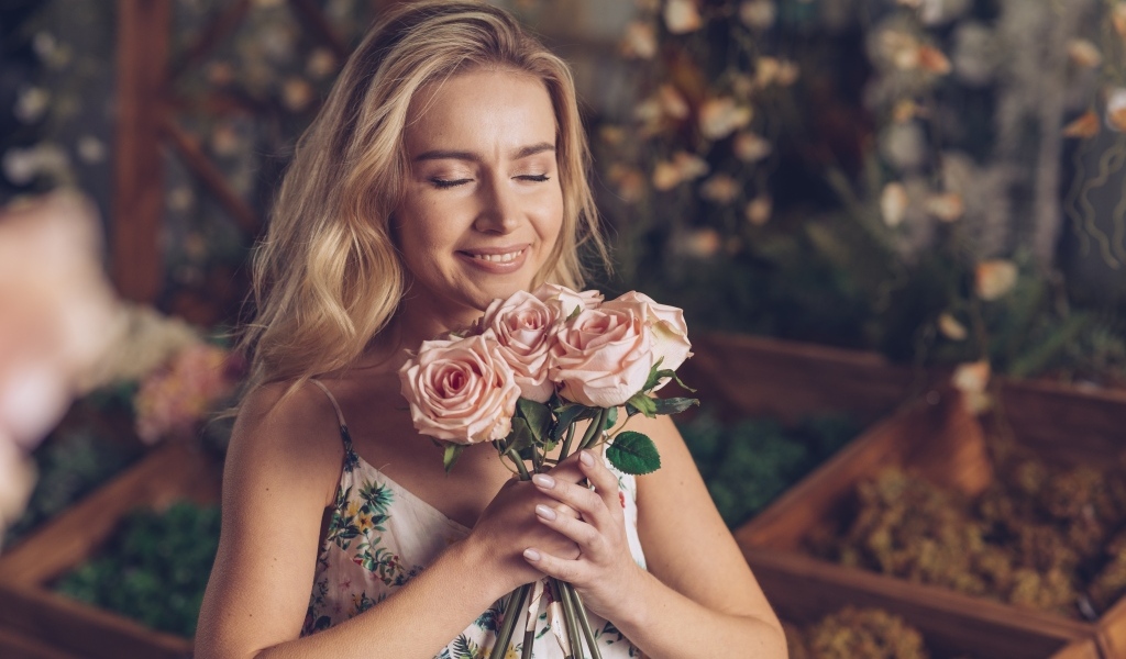 Девушка с букетом роз с закрытыми глазами