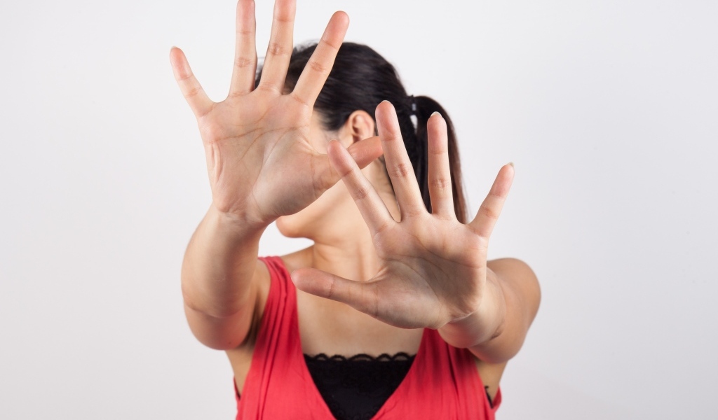 Девушка закрывает лицо руками