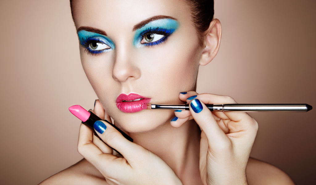 Девушке делают красивый яркий макияж