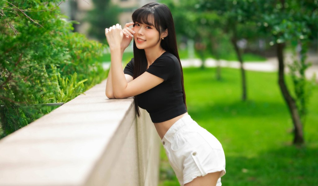 Молодая азиатка в белых шортах и футболке