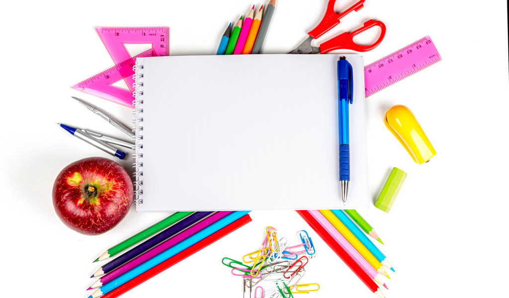 Много канцелярии с блокнотом и яблоком на белом фоне