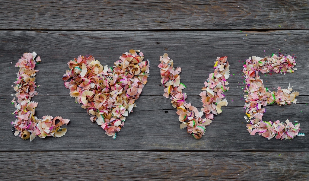 Надпись любовь из стружки карандашей на деревянном фоне