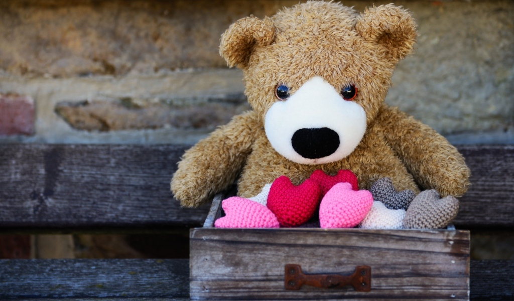 Игрушечный медвежонок с сердечками в деревянном ящике