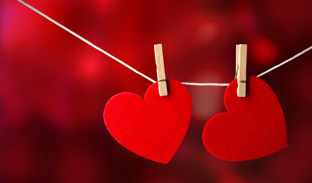 Два красных сердца висят на веревке
