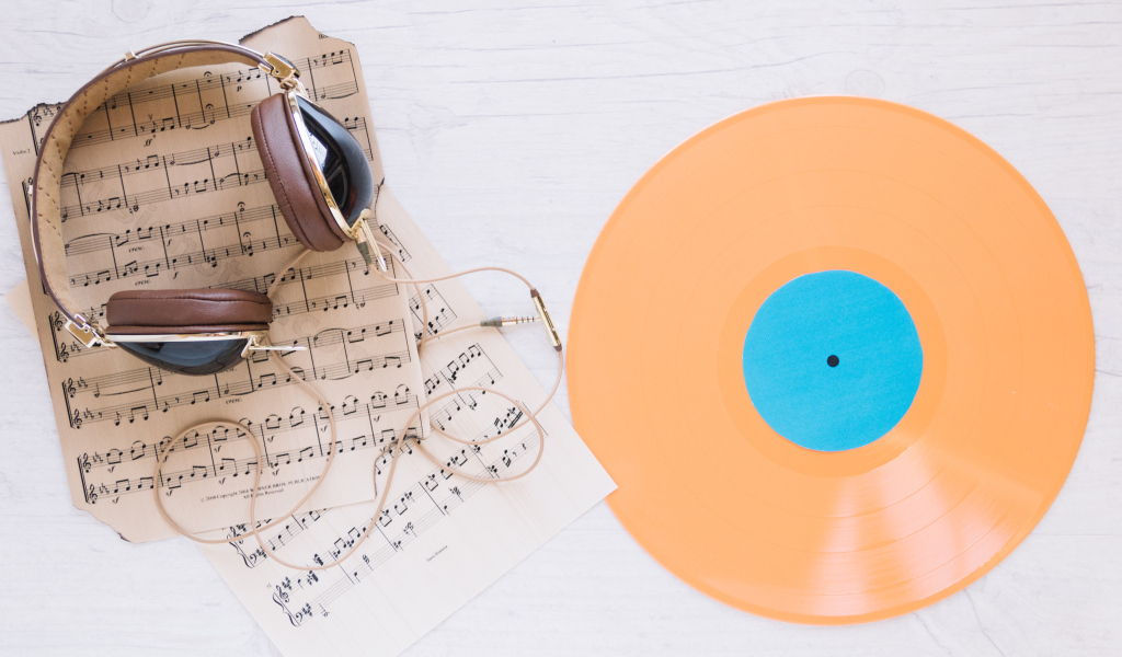 Наушники, ноты и виниловая пластинка на белом фоне
