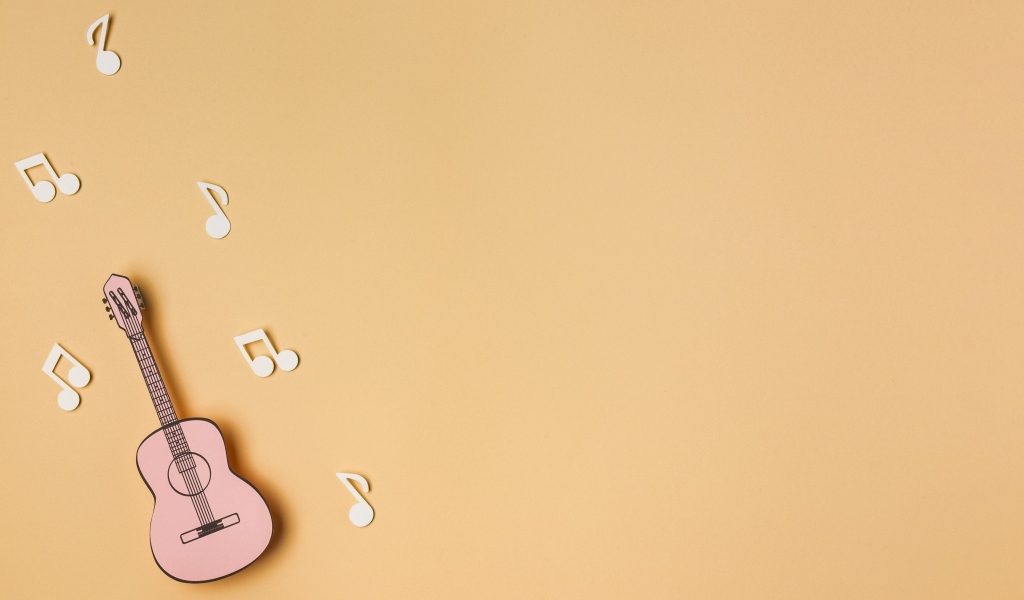 Маленькая гитара с нотами на бежевом фоне