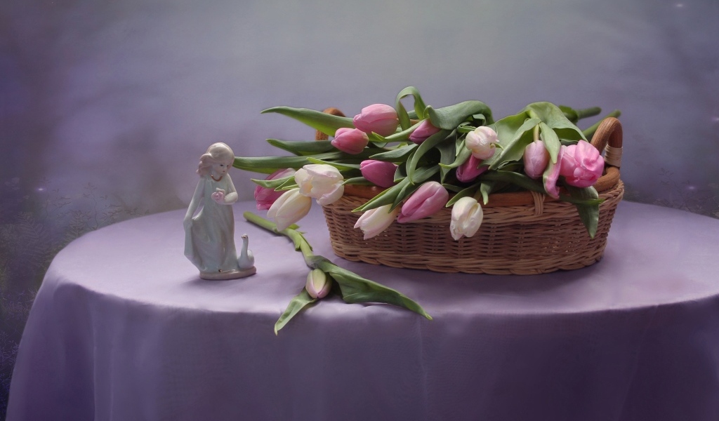 Корзина тюльпанов на столе со статуэткой