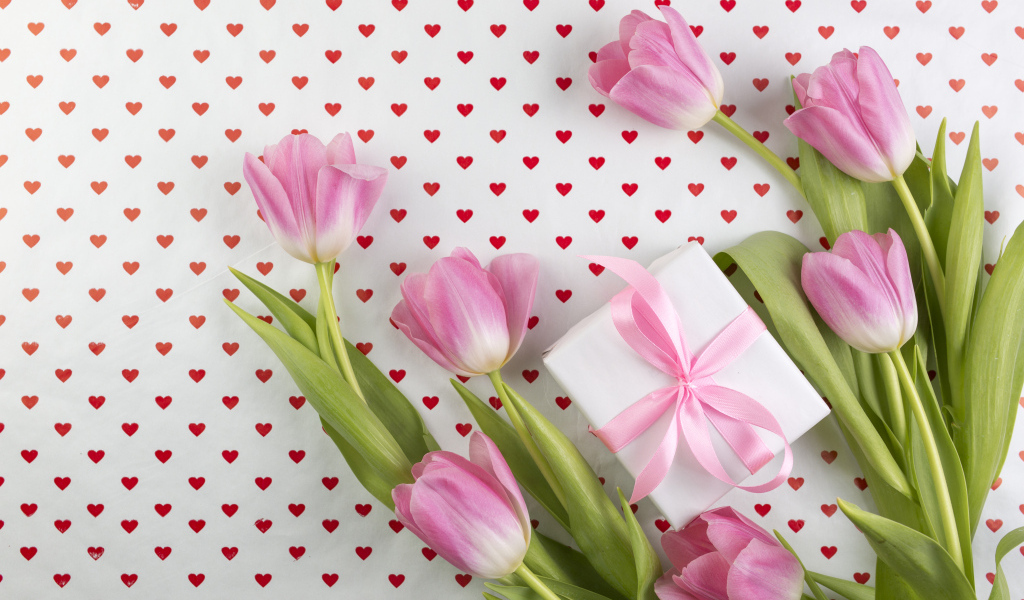 Букет розовых тюльпанов с подарком на фоне с сердечками
