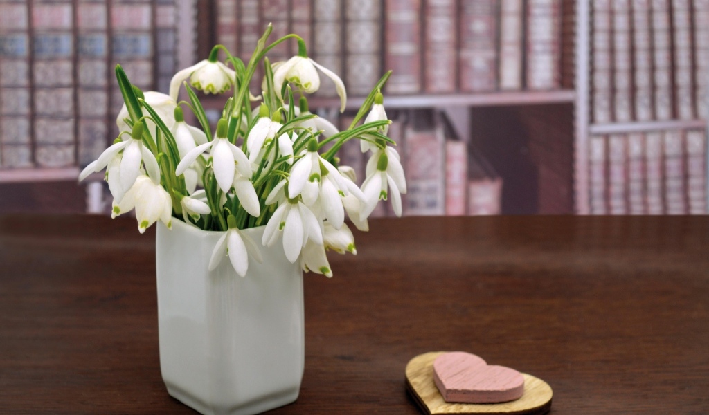Букет белых подснежников в вазе на столе с сердечками