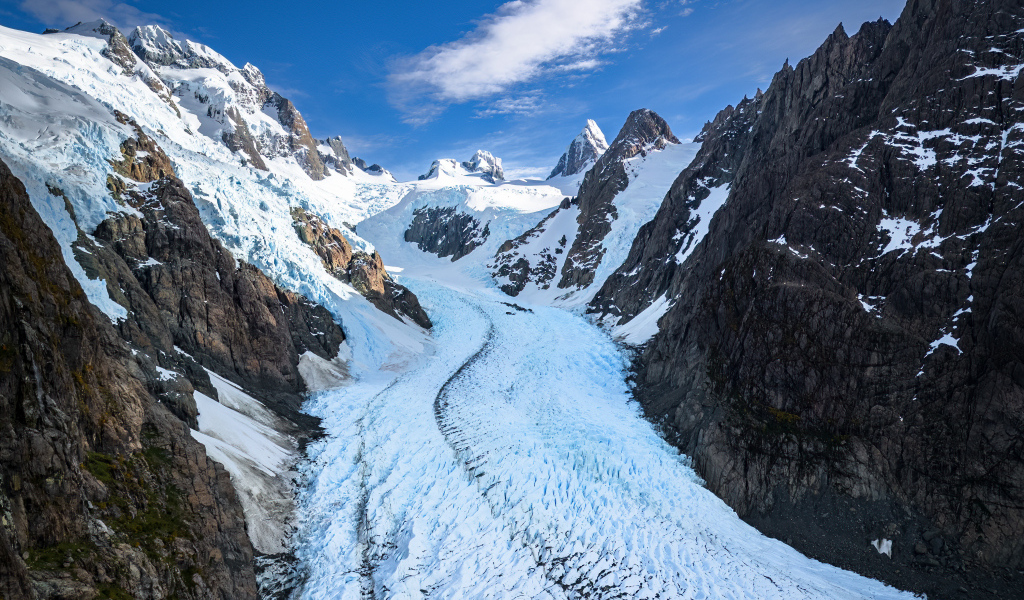 Заснеженная заледеневшая дорога между гор